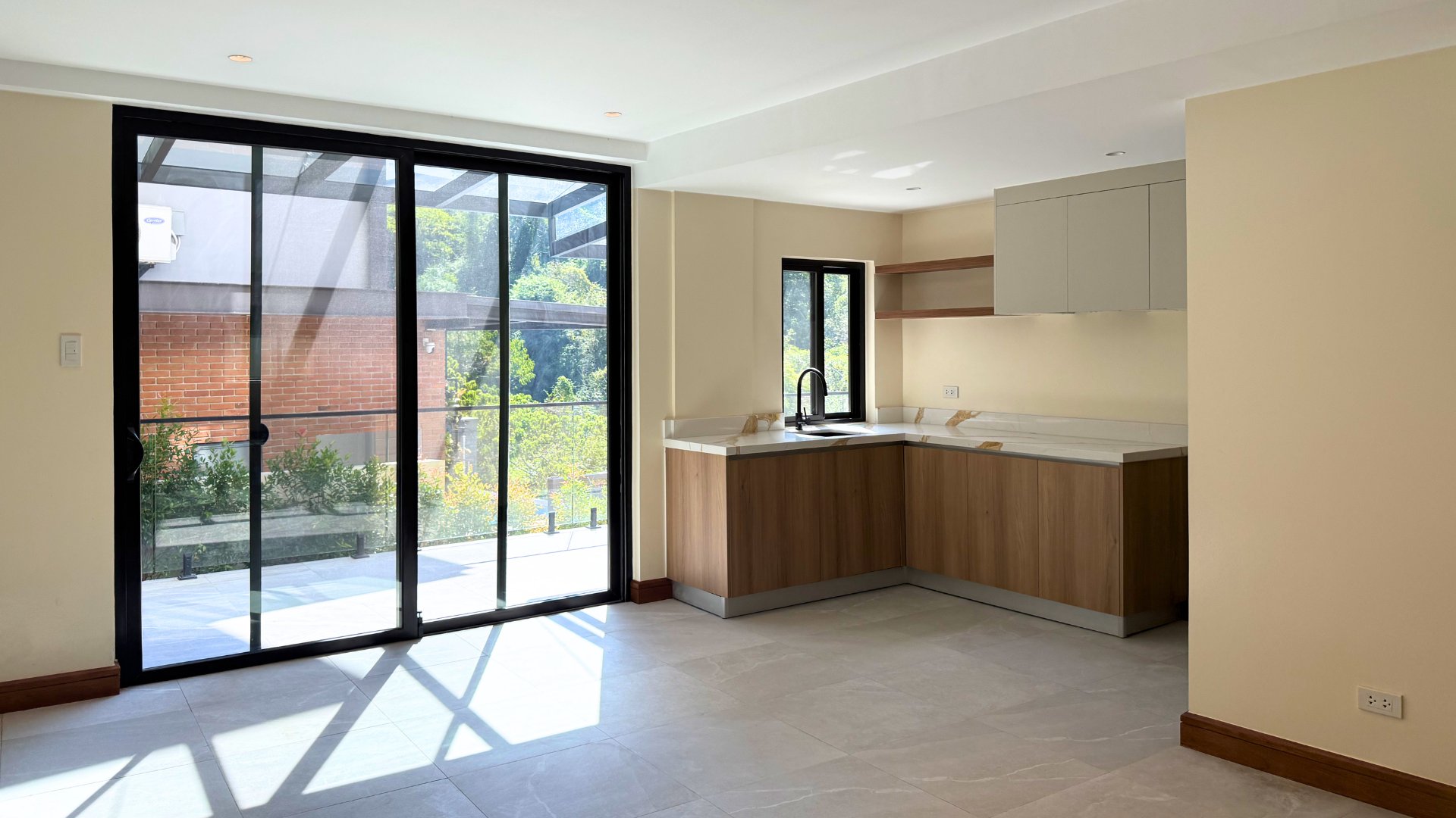 Living area opening to infinity pool and forest