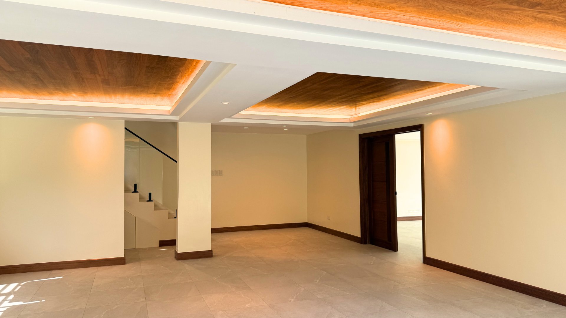 Lower ground multipurpose area with wood ceiling panels and cove lighting