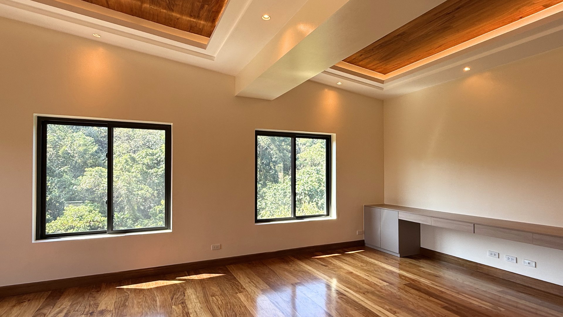 Master bedroom study nook with built-in desk and forest view